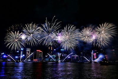 Low angle view of firework display at harbor during night