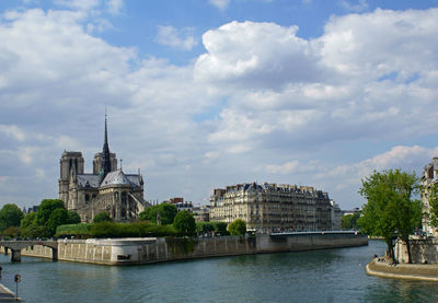 Temple by river against sky in city