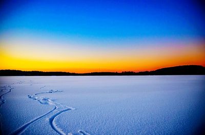 Scenic view of snow covered landscape at sunset