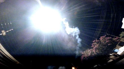 Low angle view of illuminated fireworks against sky at night