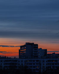 Modern buildings against sky at sunset