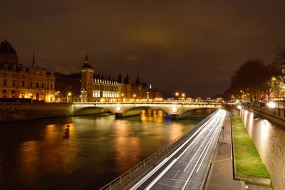 Illuminated bridge over river at night