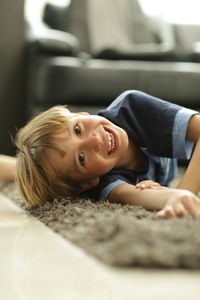 Portrait of smiling boy lying at home
