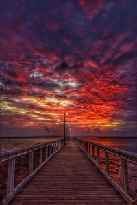 Pier over sea against sky during sunset