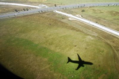 High angle view of airplane flying over field