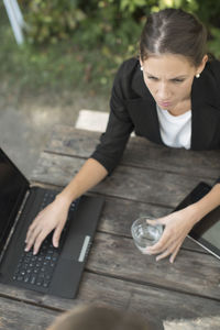 High angle view of businesswoman using laptop at outdoor cafe