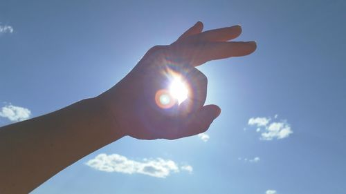 Low angle view of hand holding sun
