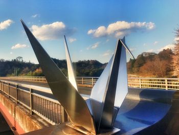 Close-up of airplane on bridge against sky