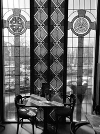 Chairs and table against stained glass at restaurant