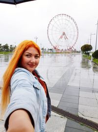 Portrait of smiling woman standing at amusement park