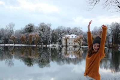Reflection of woman in lake against sky