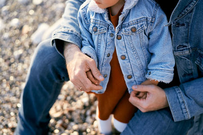 Midsection of couple holding hands