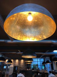 Low angle view of illuminated pendant light hanging in restaurant