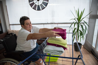 A disabled person on a wheelchair washes laundry