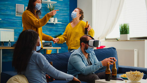 Rear view of people sitting on sofa at home