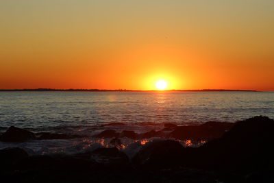 Scenic view of sea against dramatic sky during sunset