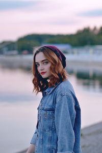 Portrait of woman standing against lake