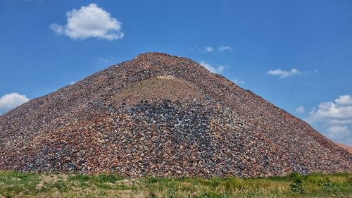 Pile of discarded bricks against sky