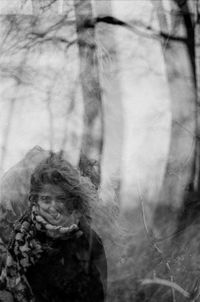 Portrait of young woman against trees