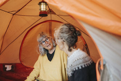 Two senior women sitting in tent