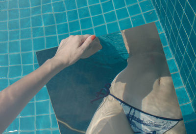 Low section of woman swimming in pool