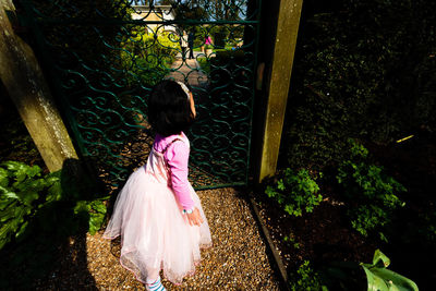 Rear view of woman standing by plants