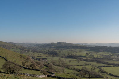 Scenic view of agricultural landscape against clear sky