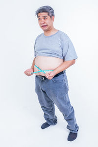 Portrait of young man standing against white background