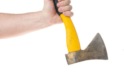 Close-up of hand holding cross against white background