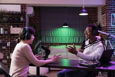 Man and woman podcasting at studio