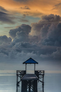 Lifeguard hut on beach against sky during sunset
