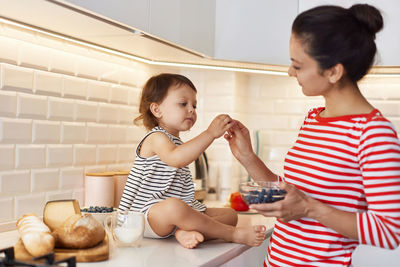 Side view of mother and daughter at home