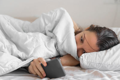 Midsection of woman lying on bed