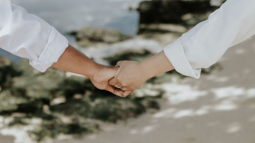 Midsection of couple holding hands