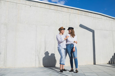 Friends standing against wall