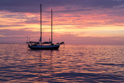 Boat sailing in sea at sunset