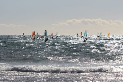 Panoramic view of people on sea against sky