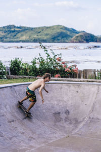 Young man skateboarding in concrete pool