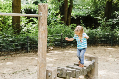 Boy playing with plants against trees