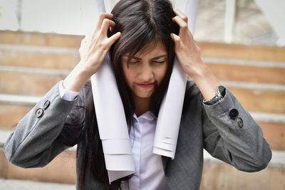 Worried businesswoman with hands in hair on steps