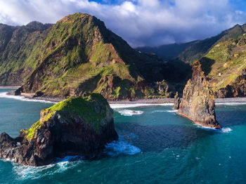 Scenic view of sea and mountains against sky