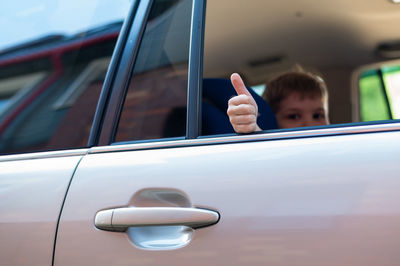 Portrait of boy seen through car window