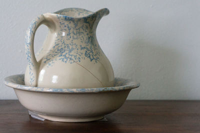 Close-up of cracked porcelain jug in bowl on table