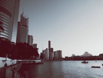 View of river and buildings against clear sky