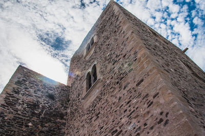 Low angle view of old building against cloudy sky