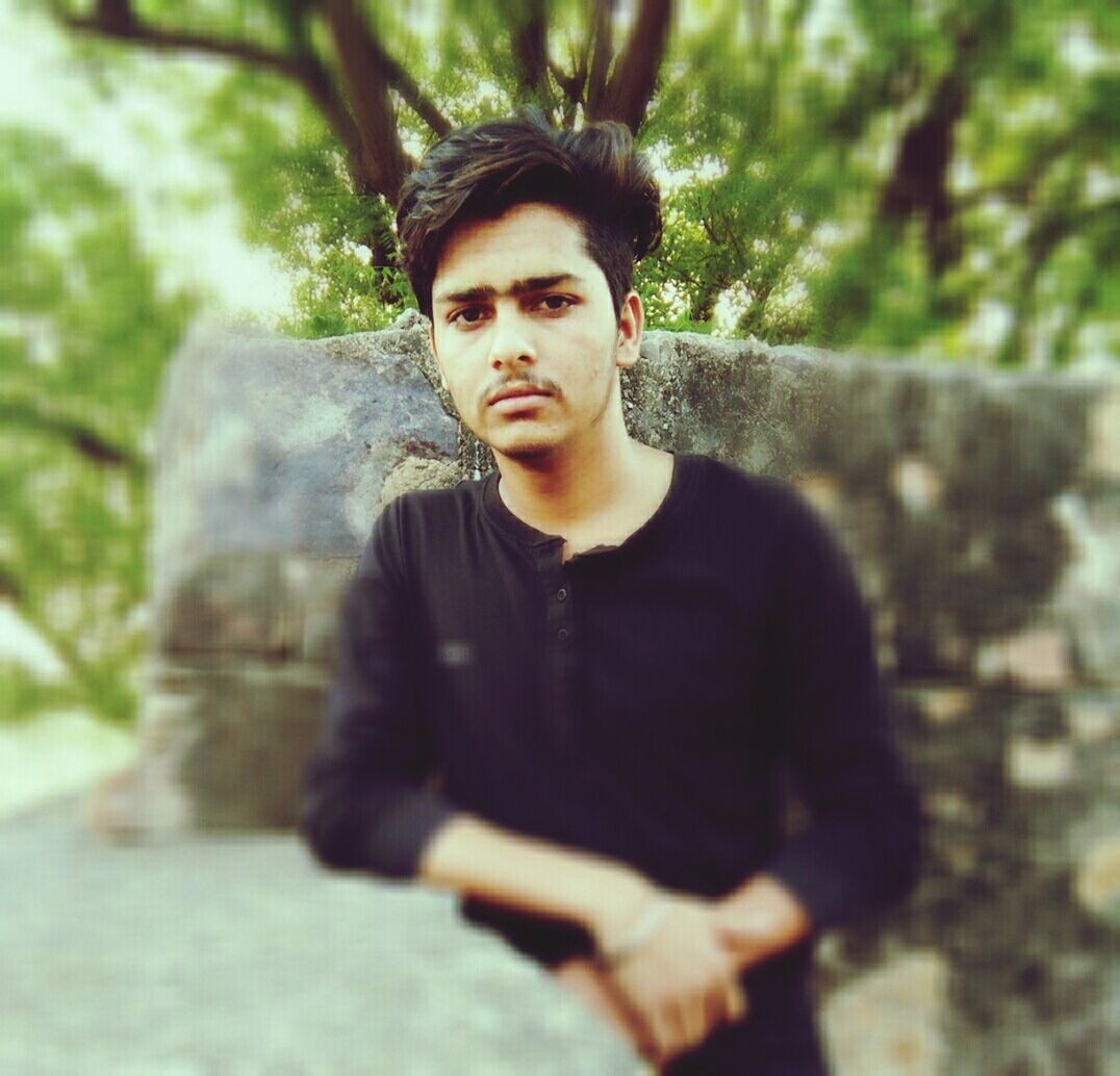 PORTRAIT OF YOUNG MAN IN FOREST