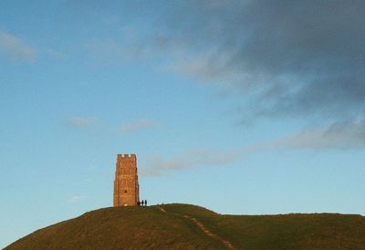 Low angle view of lighthouse on hill against sky