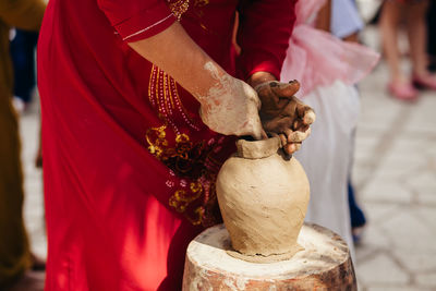 Midsection of woman making pottery on table