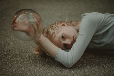 Portrait of girl lying on floor at home