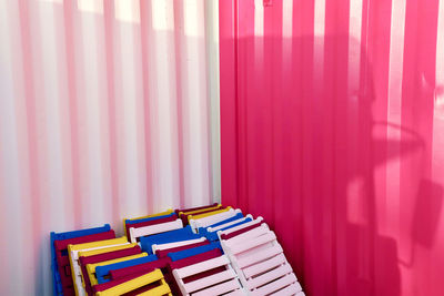 Colorful folding chairs against corrugated iron